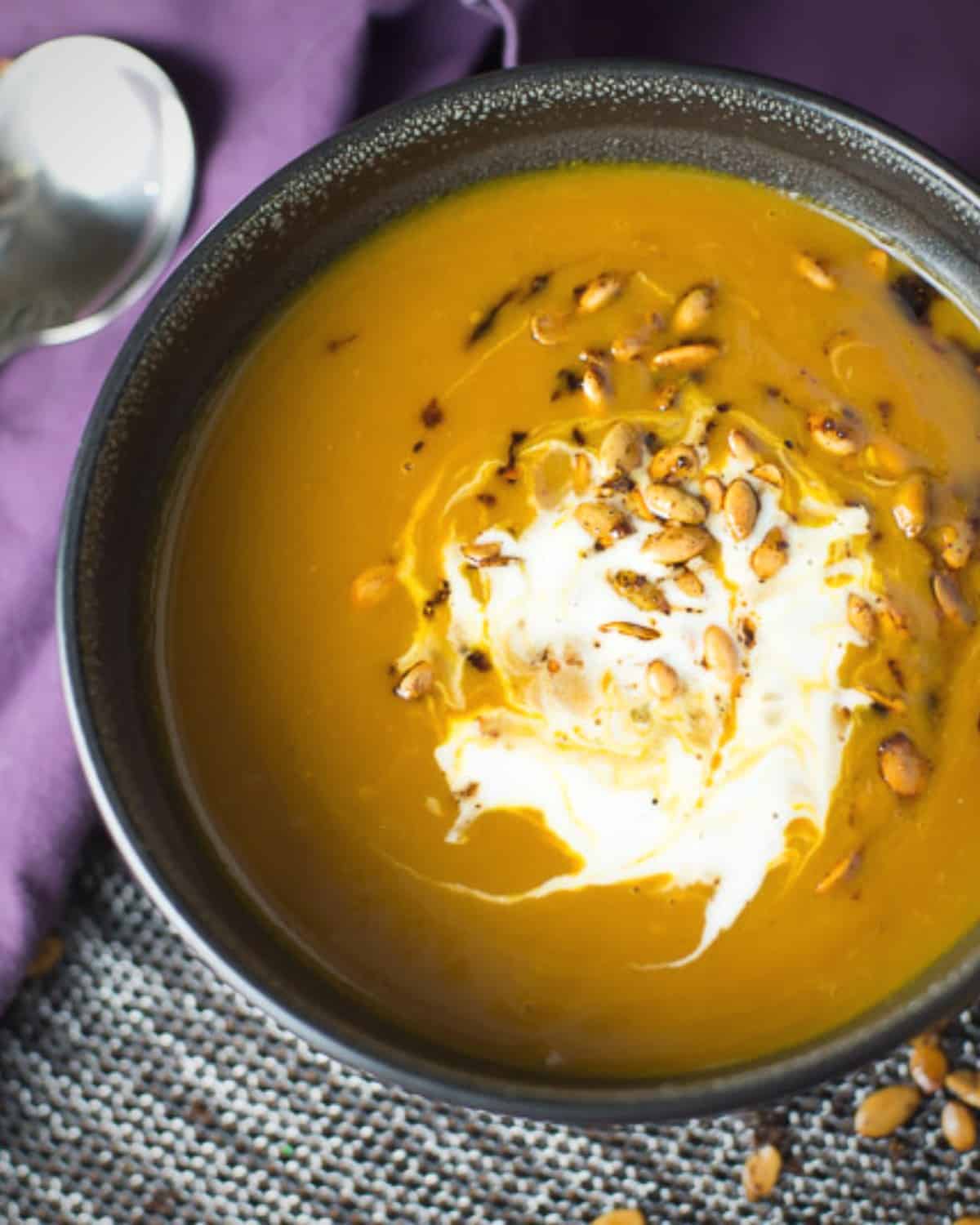 spicy pumpkin soup served with toasted pepitas and creme fraiche