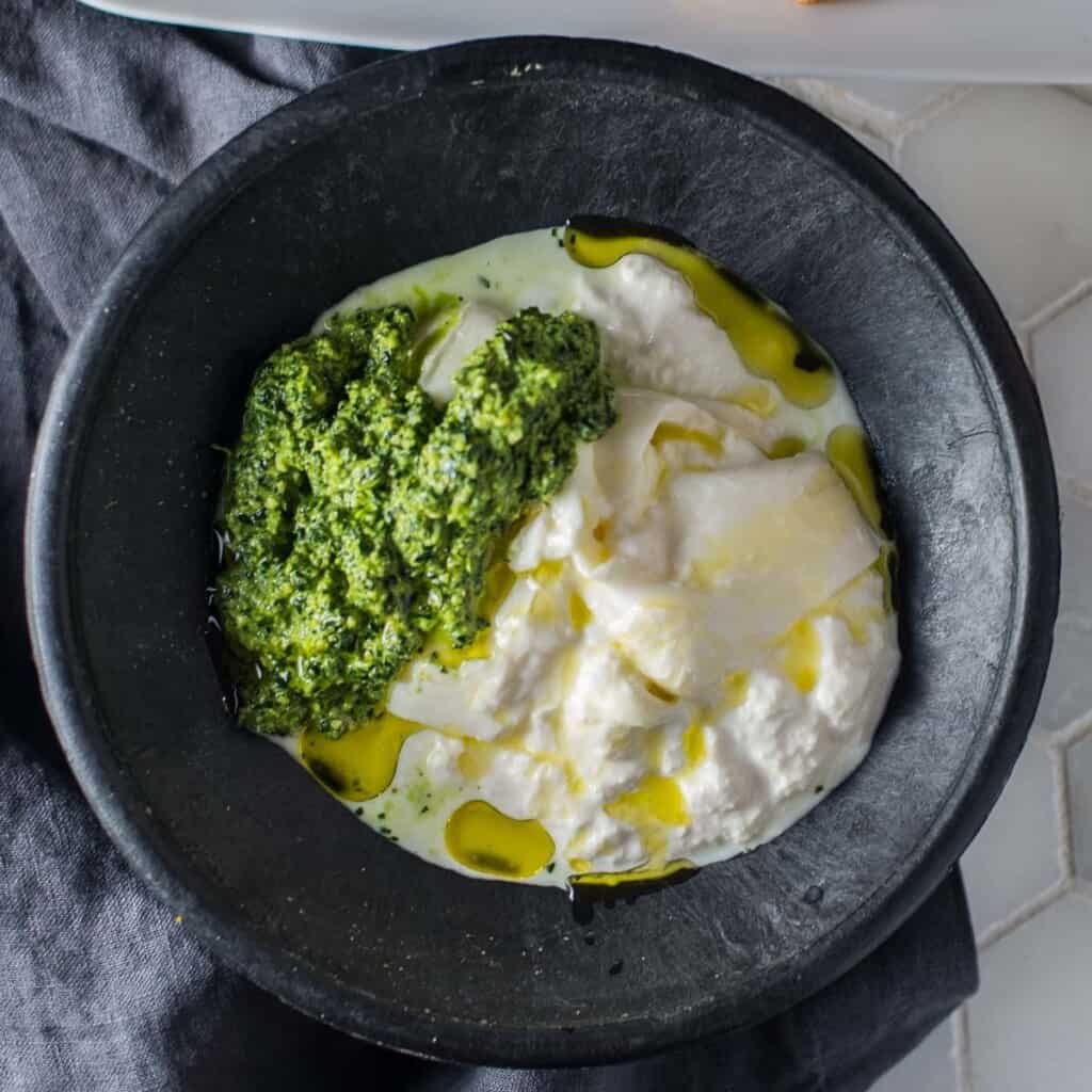 kale pesto recipe served with burrata and drizzled with olive oil.