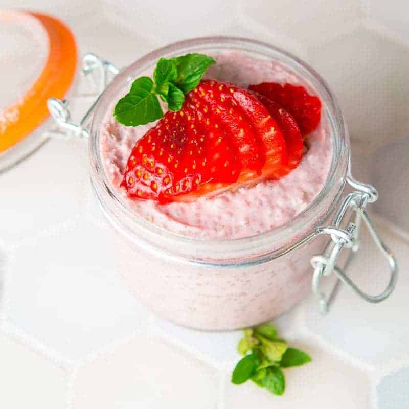 Strawberry Chia Pudding recipe in a clip top jar. topped with a fanned out fresh strawberry. recipe by foodology geel.