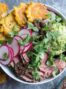 Steak salad with chimichurri sauce, guacamole, and tostones. by foodology geek