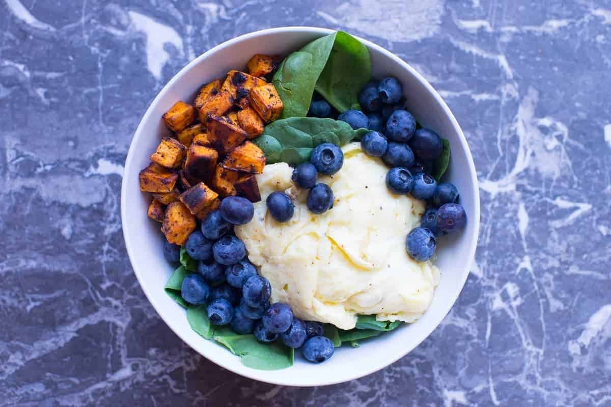 Paleo Breakfast Bowl Recipe with eggs, blueberries, spinach, and roasted sweet potatoes. 