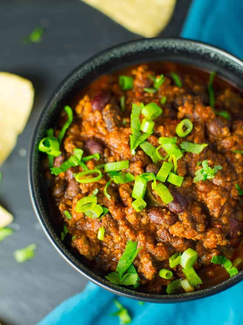 Chili is the perfect make-ahead one pot dinner. It's also easy to freeze and reheat. #mealprep #onepotdinner Ground beef and bean chili recipe. Sprinkled with green onions. Served with tortilla chips.