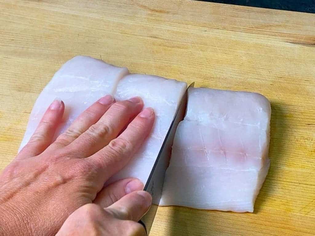 halibut being portioned into three equal pieces