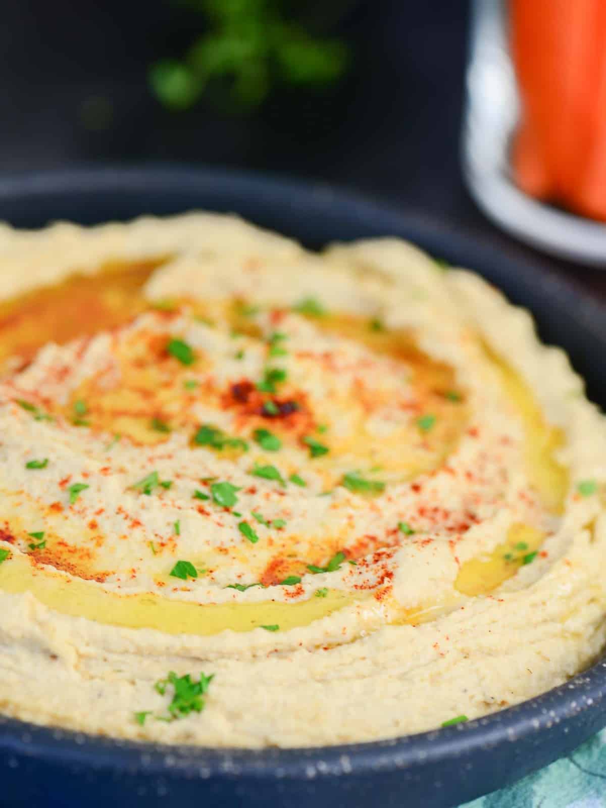 homemade hummus with olive oil drizzled on top and a sprinkle of paprika