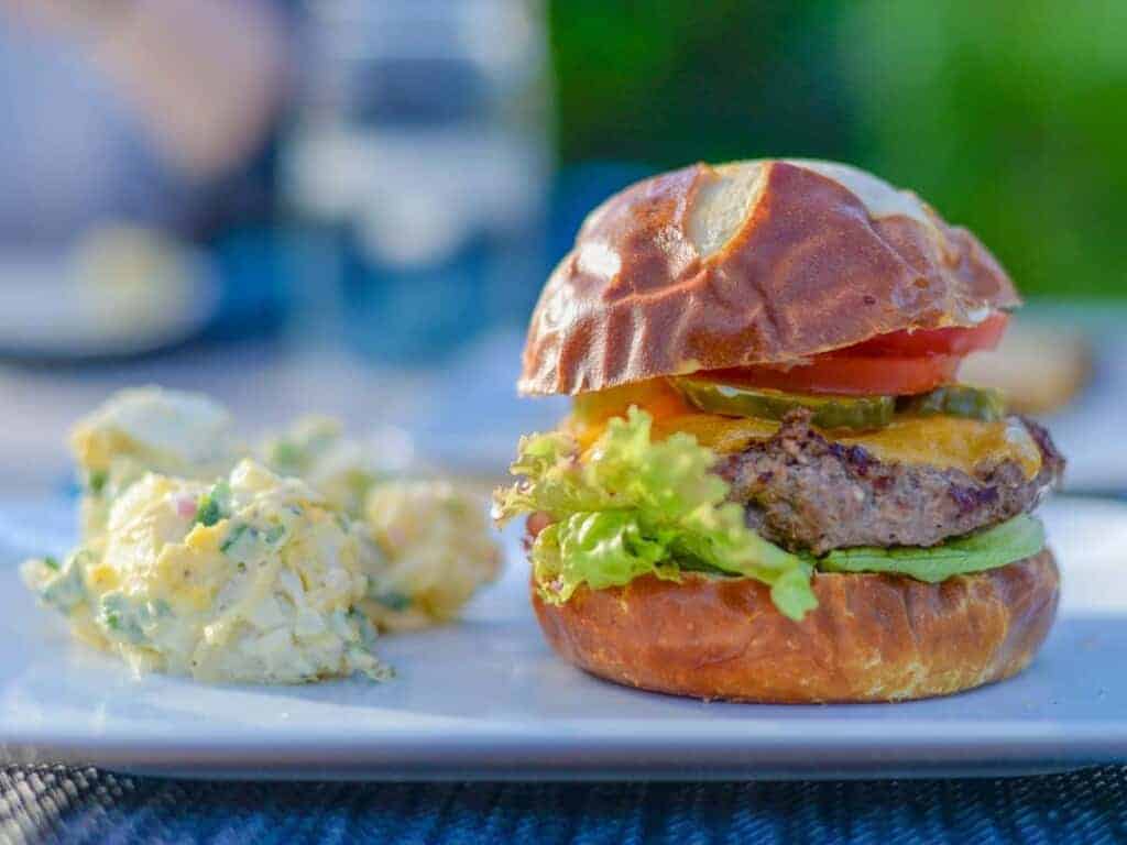 grilled burger served with classic creamy potato salad