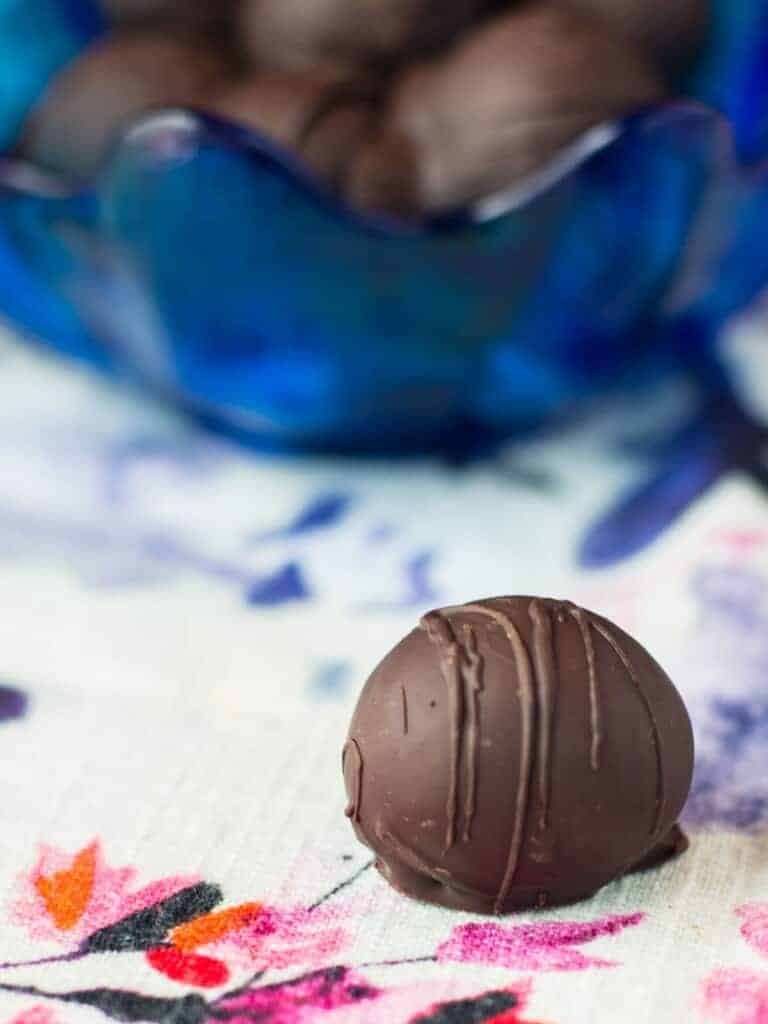 holiday rum truffles in a bowl with one sitting on the table