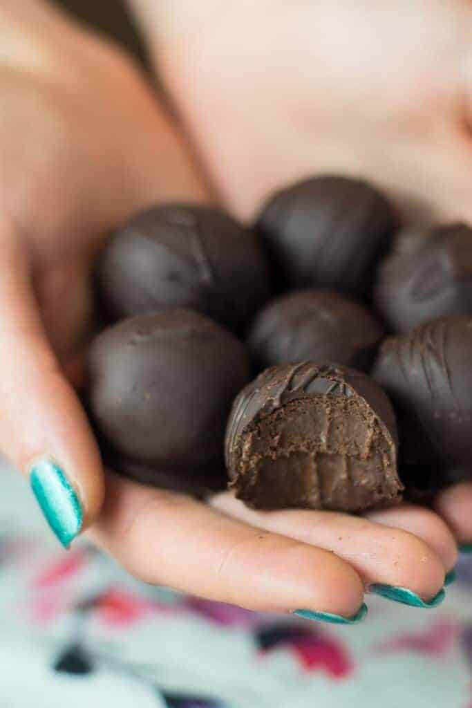 a handful of boozy rum truffles, one has a bite taken out