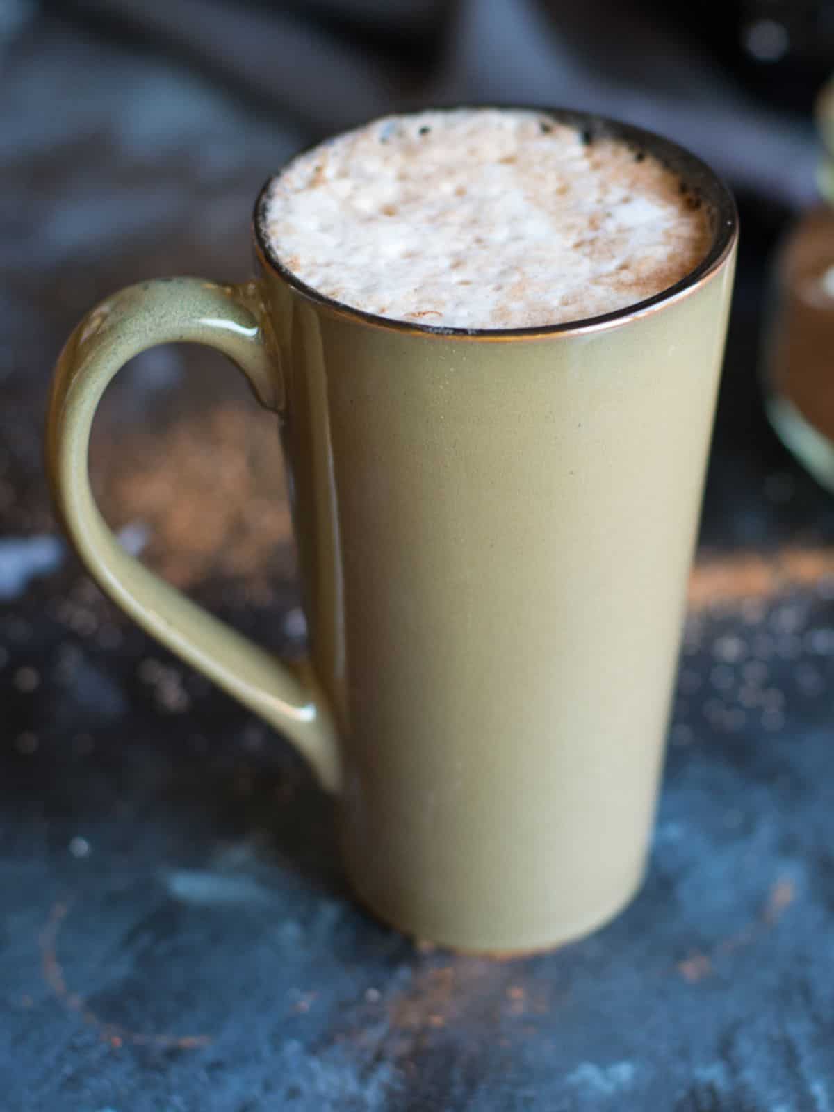 Close-up of creamy café mocha hot chocolate topped with foam and cinnamon