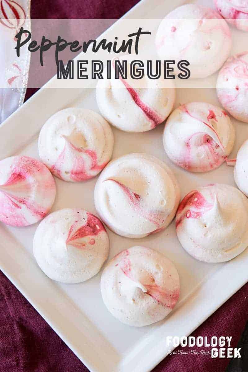 Pink and white peppermint meringues on a white platter.