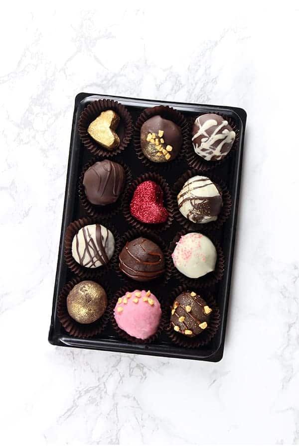 A dozen beautifully decorated chocolate truffles.