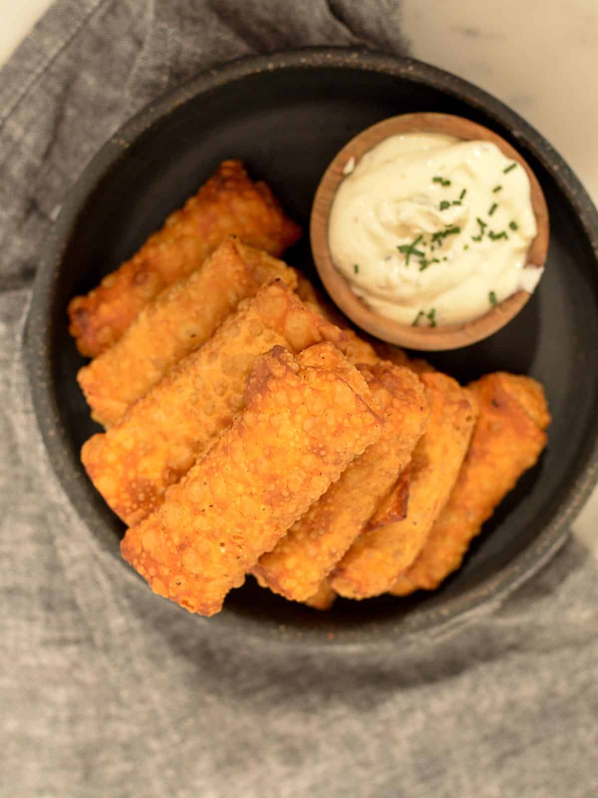 a plate of buffalo chicken egg rolls with blue cheese sauce 