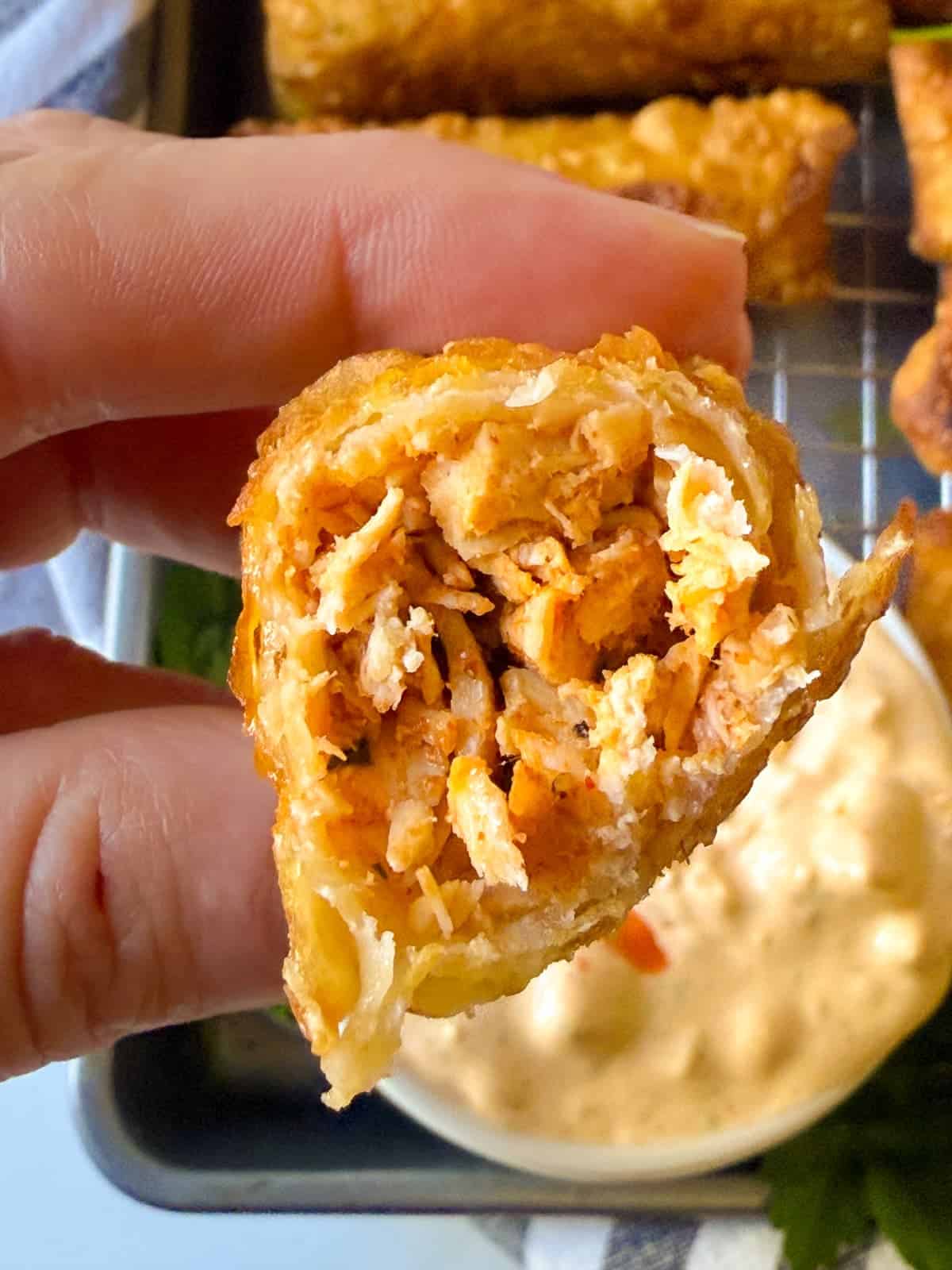 Buffalo Egg Rolls cut in half, revealing a creamy, spicy buffalo chicken filling wrapped in a crunchy shell. The ultimate party snack!