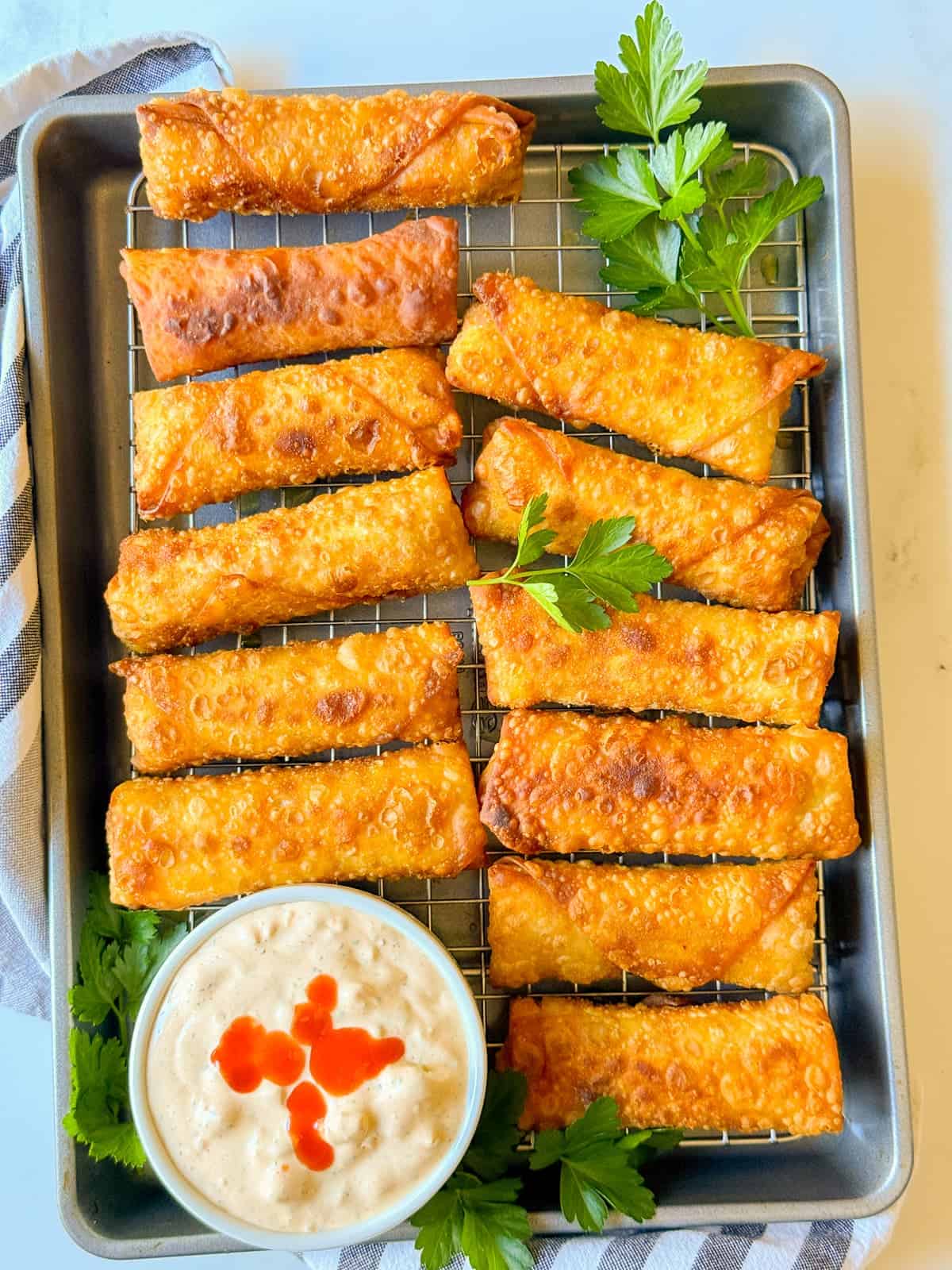 a platter of buffalo chicken egg rolls served with buffalo ranch dipping sauce