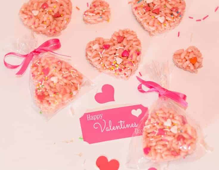 This cute Valentine's Day Rice Crespie treatment variation will make adorable edible homemade gifts. #homemade #gifts #ricekrispretreats Valentine's Rice Crespie deals in variations. Cut into pink and heart shapes. A package with a homemade Valentine's Day gift tag.
