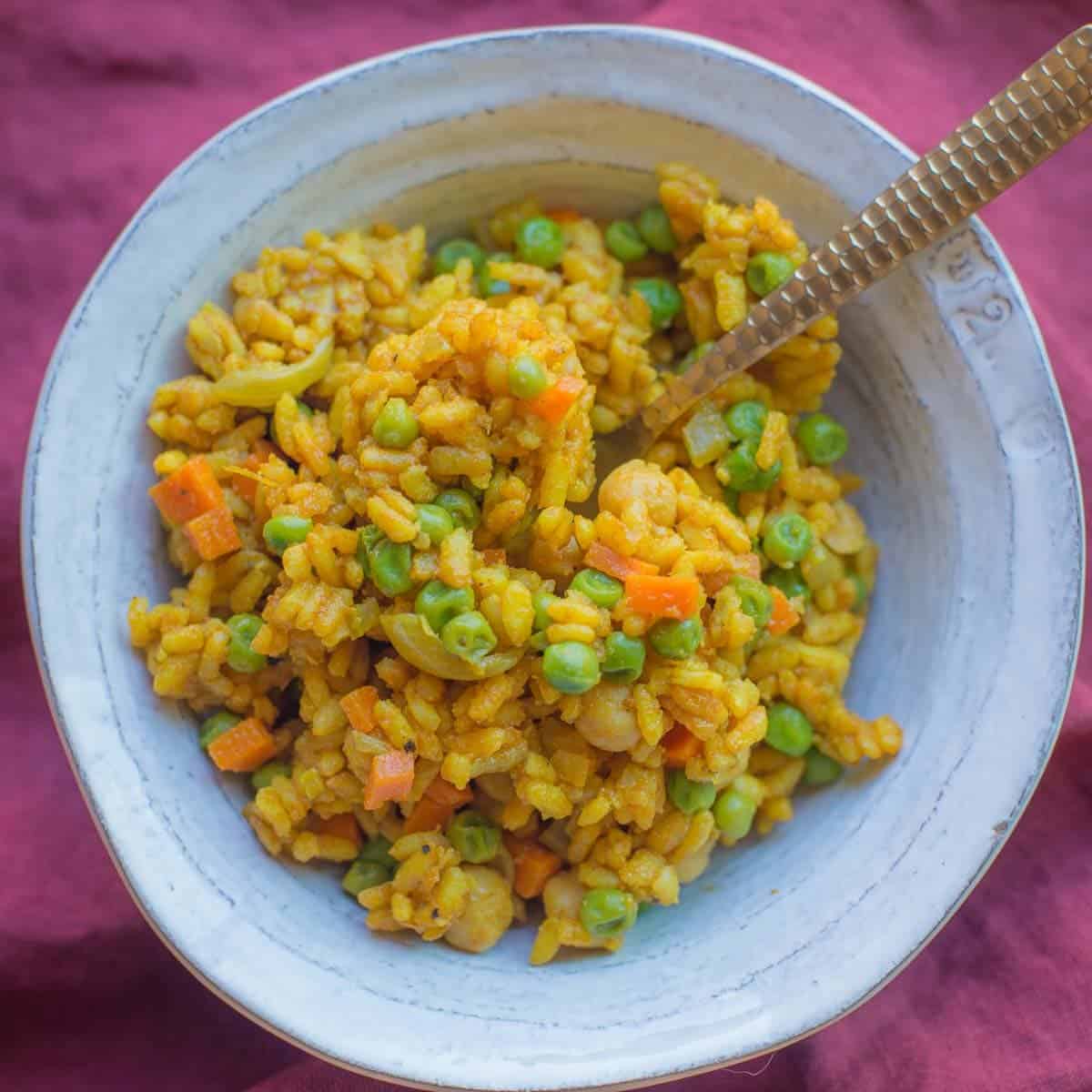 Curry Risotto made with arborio rice, yellow curry, vegetable broth, peas and carrots.