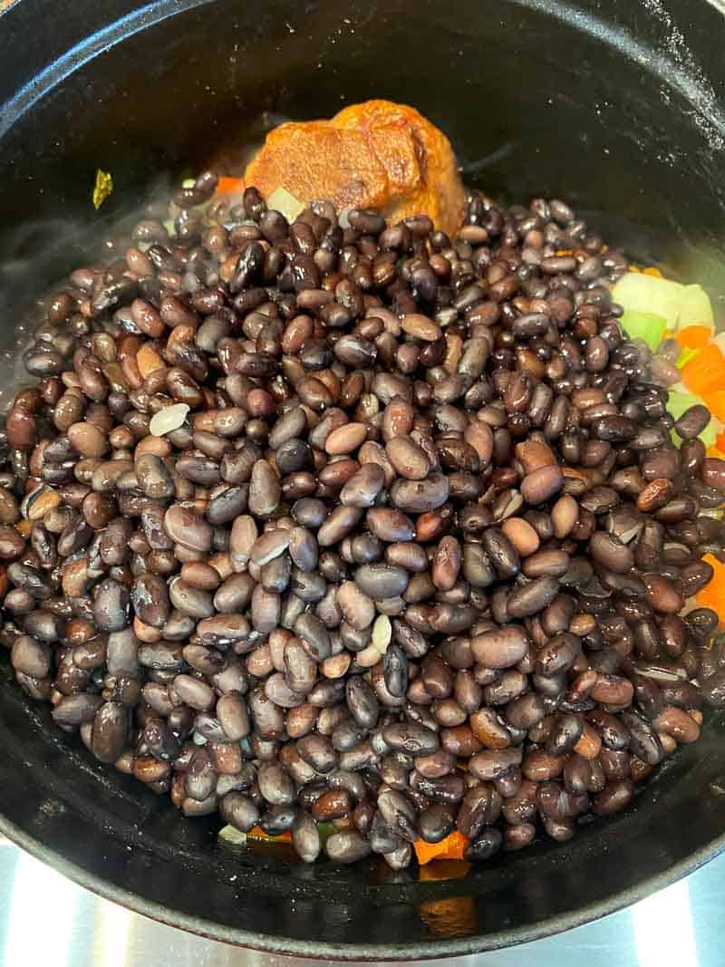 Add the presoaked black beans to the dutch oven or stock pot.