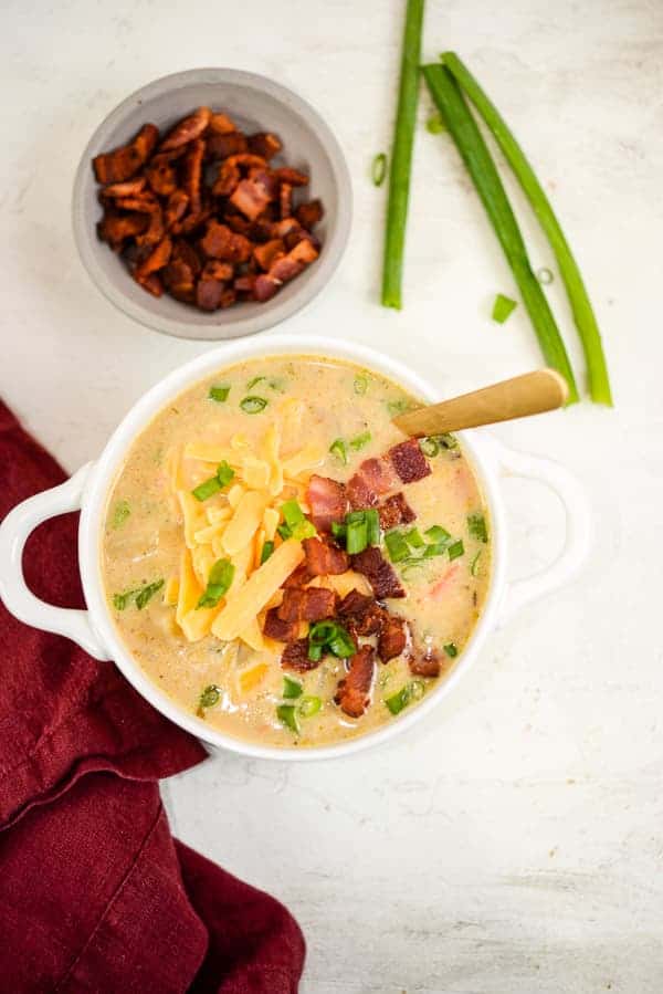 Bowl of homemade potato soup with bacon, cheese, and green onions.