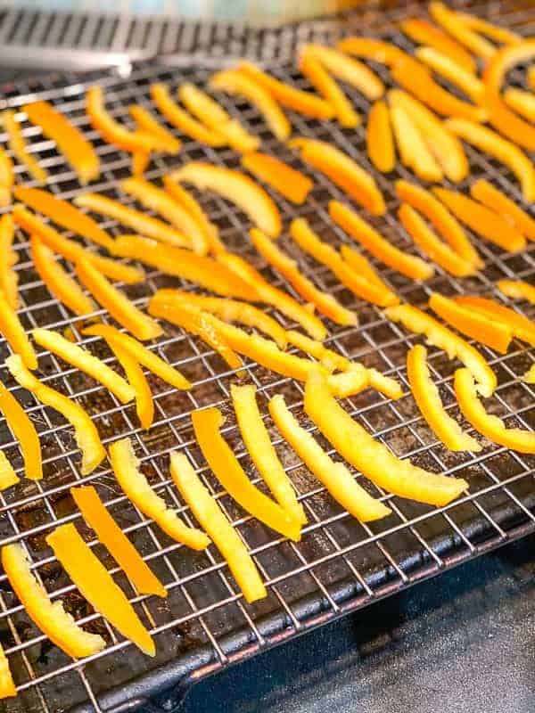 orange peels drying on a wire rack after boiling in sugar syrup. 