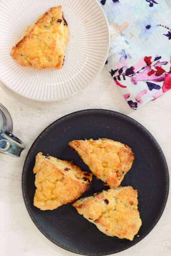 cranberry and orange scones on a plate with a flowery napkin