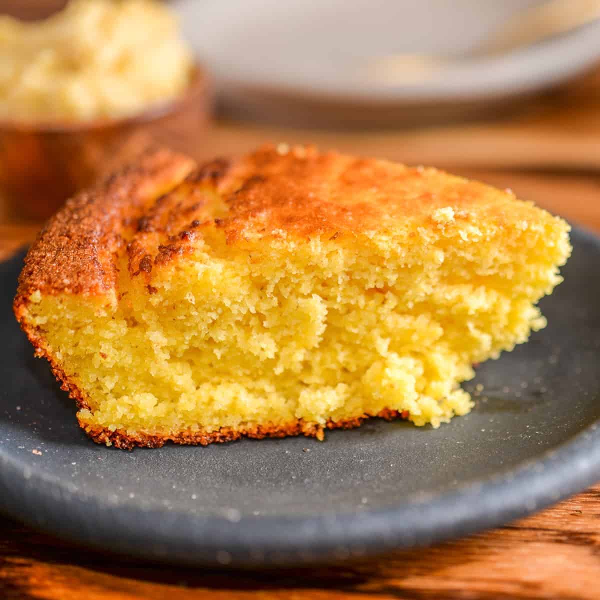 slice of fluffy cornbread on a black plate