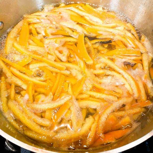 orange peels boiling in sugar syrup, making candied orange peel
