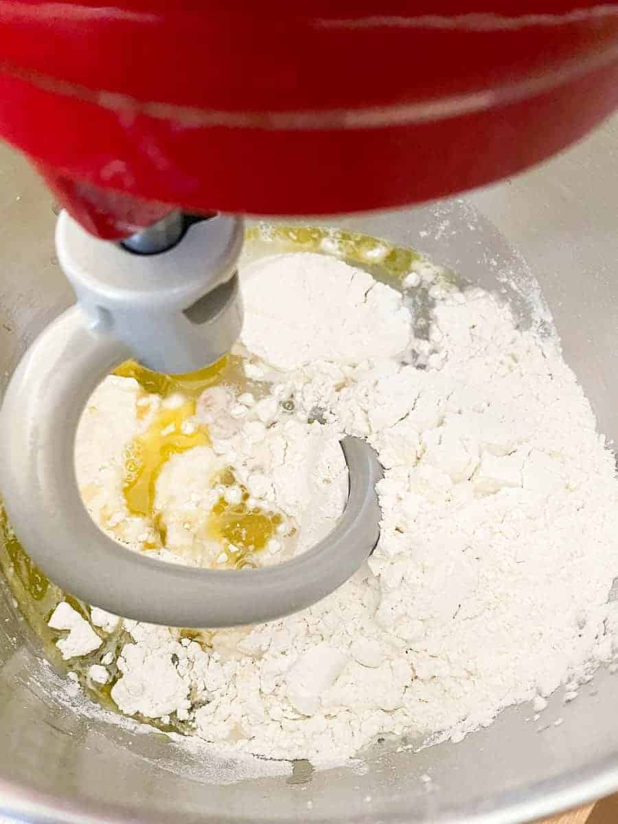 the ingredients for homemade french bread in a kitchen aid stand mixer, fitted with dough hook | foodology geek