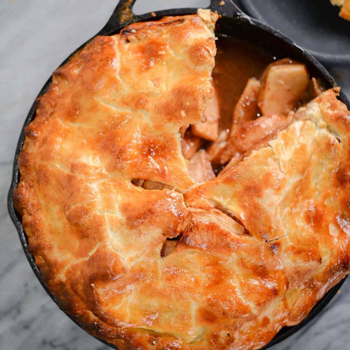 cast iron baked apple pie recipe with a slice cut out