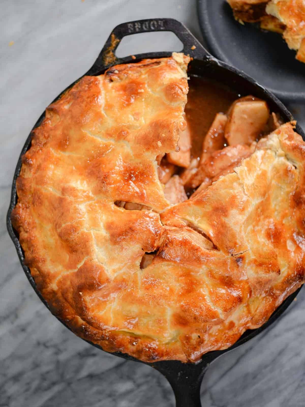 cast iron baked apple pie recipe with a slice cut out