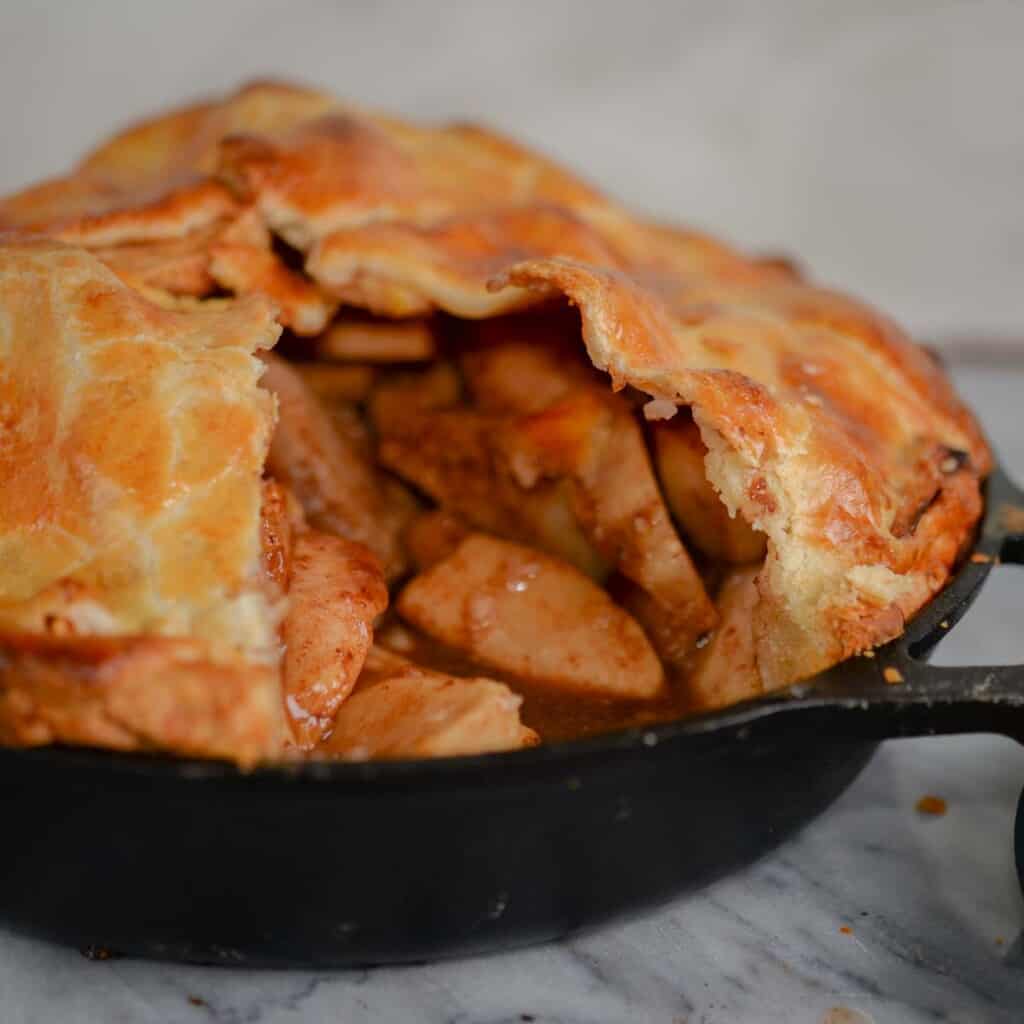 apple pie filling with caramel sauce baked in a cast iron skillet