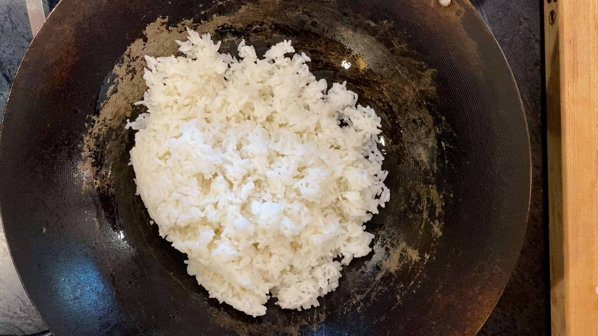 how to make plain fried rice. oil and rice in a wok