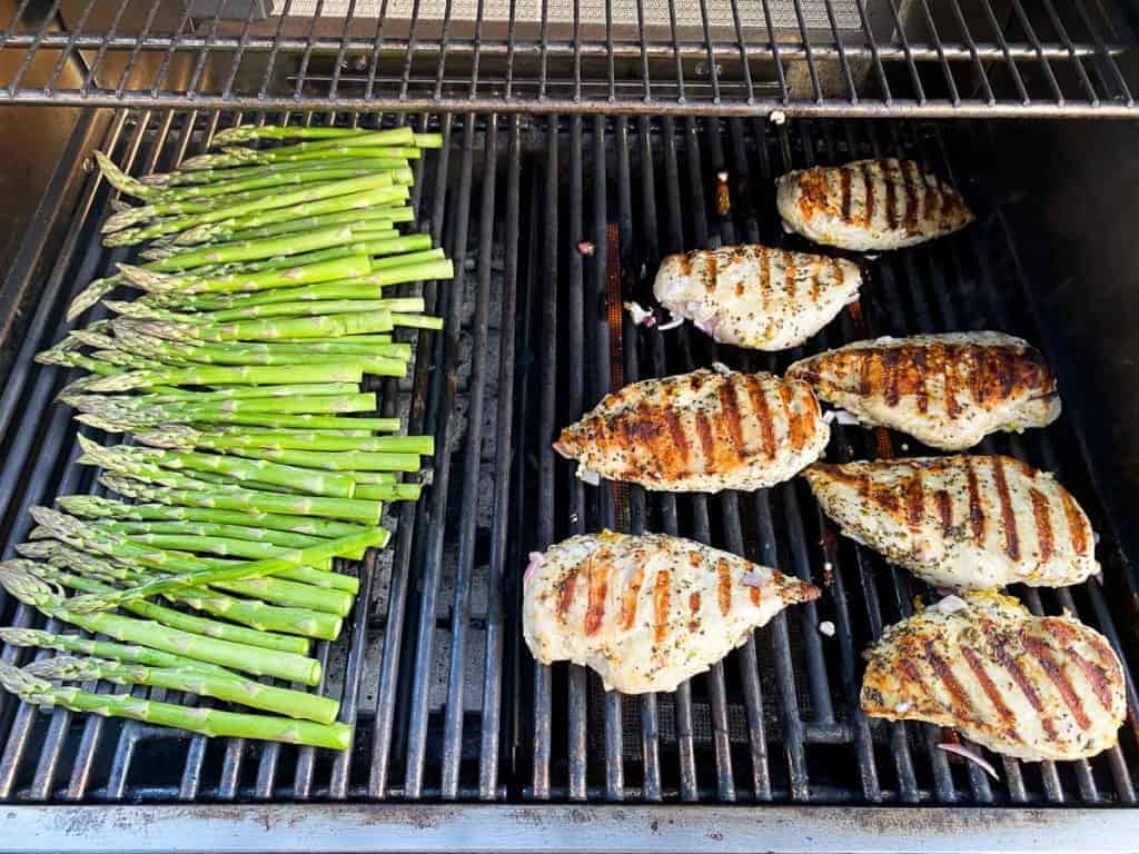 grilled chicken breasts and asparagus on a grill