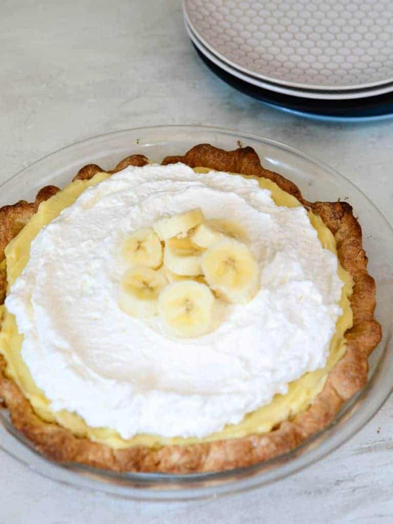 top the banana pie with fresh whipped cream and more fresh bananas