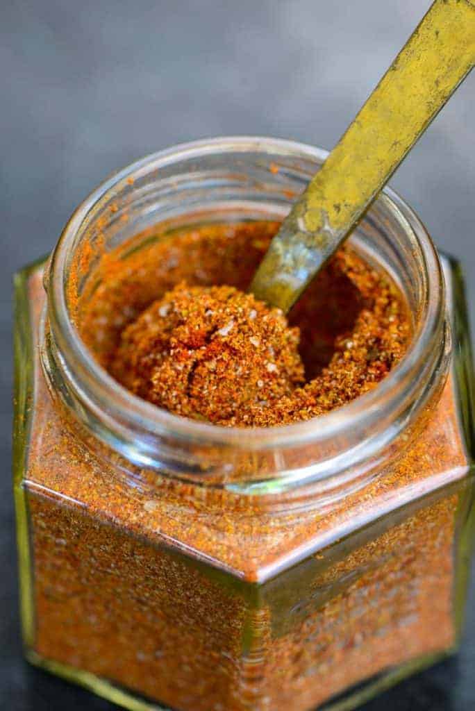 bbq rub in a jar with a gold teaspoon