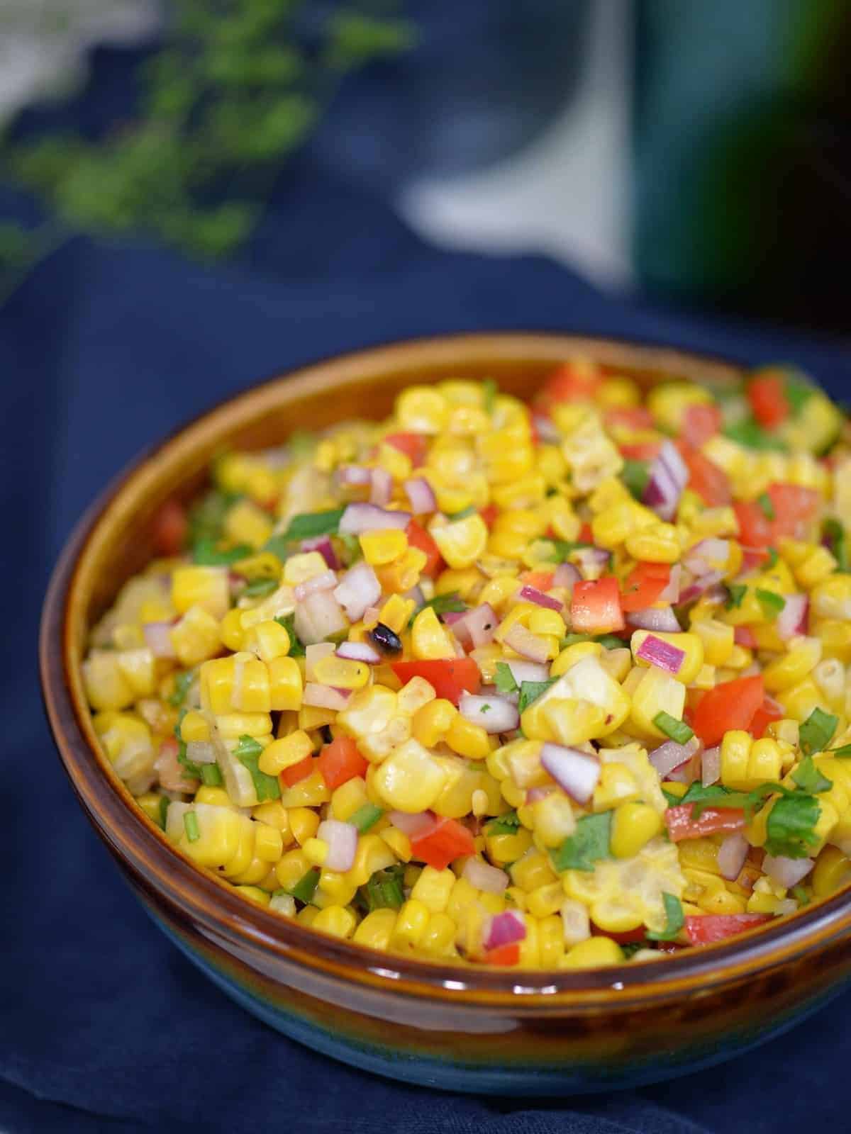 easy corn salsa recipe in a bowl, on top of a blue napkin | foodology geek.
