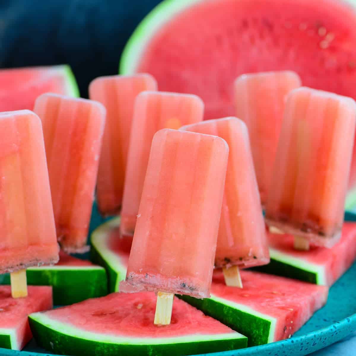 watermelon popsicles on a platter of fresh watermelon slices