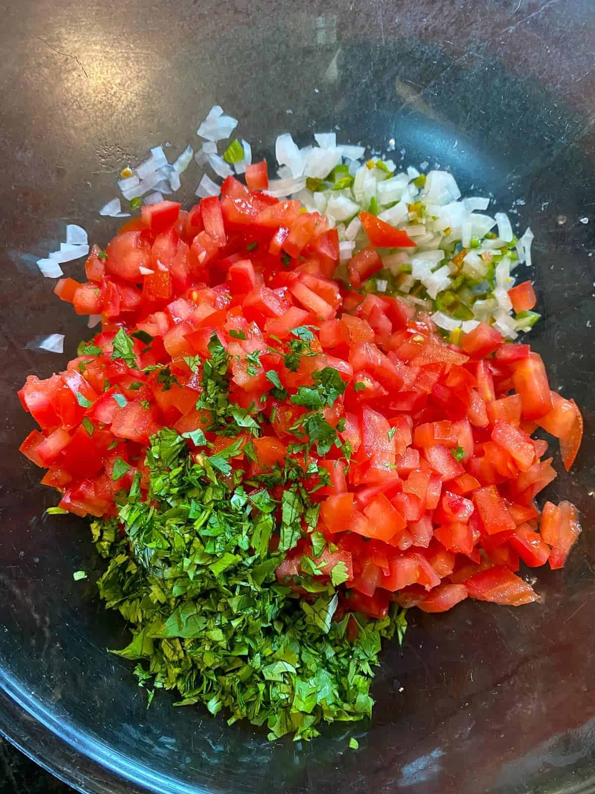 adding cilantro to pico de gallo