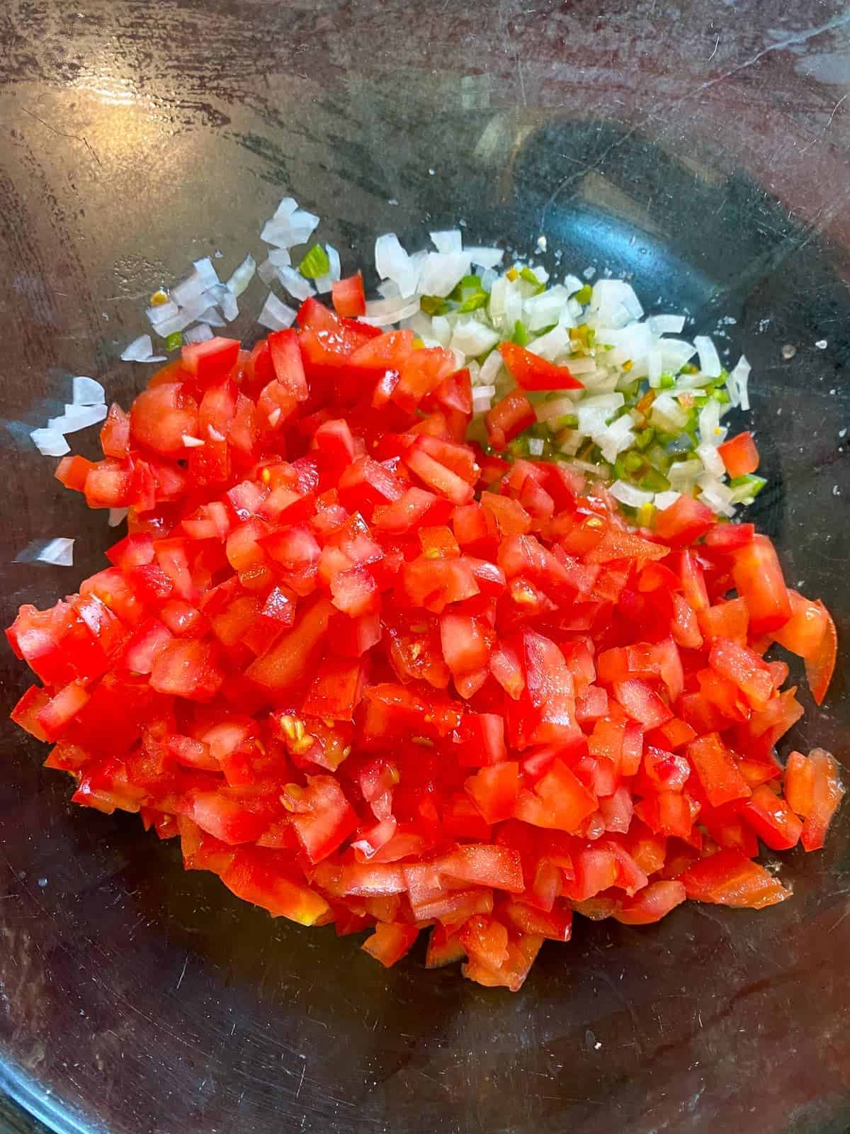 adding tomatoes to the bowl