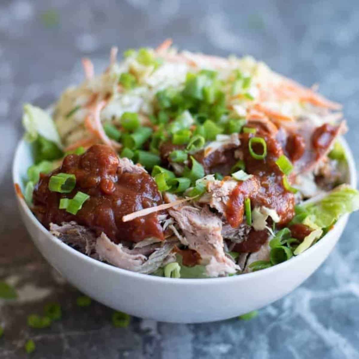 a healthy meal prep bowl pulled pork bowl with tangy homemade bbq sauce and southern stly coleslaw