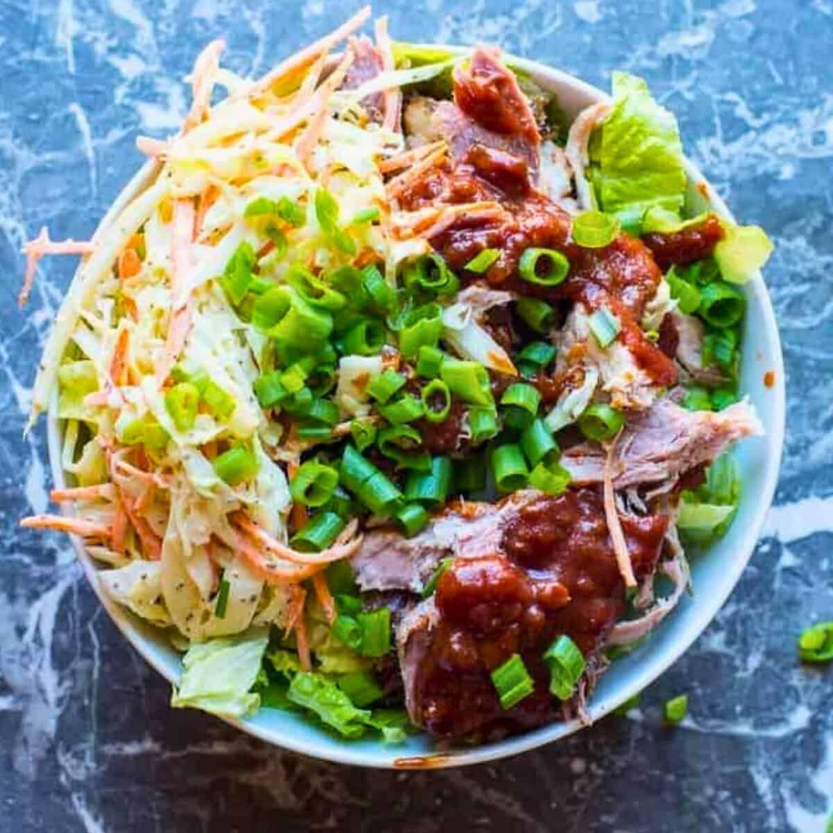 healthy pulled pork bowl with tangy bbq sauce and crunchy coleslaw
