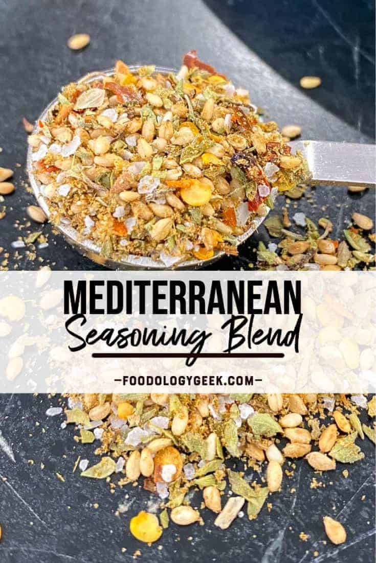 mediterranean seasoning blend pictured on a black counter top with a teaspoon full of herbs and spices