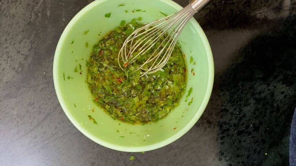 whisking chimichurri sauce