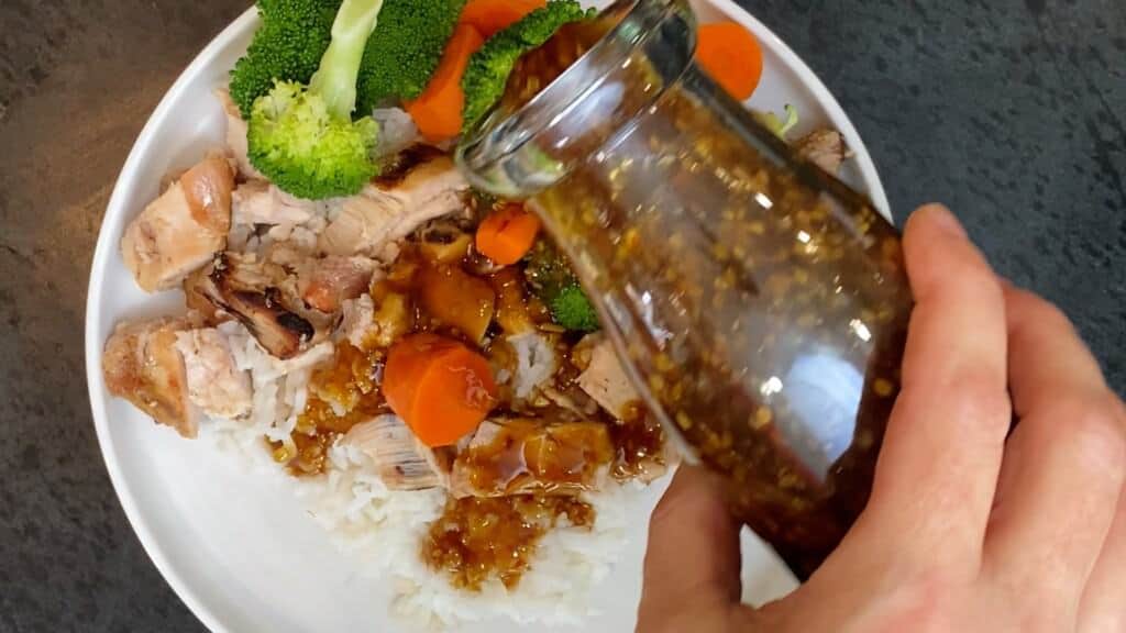 adding teriyaki sauce to the teriyaki chicken bowl