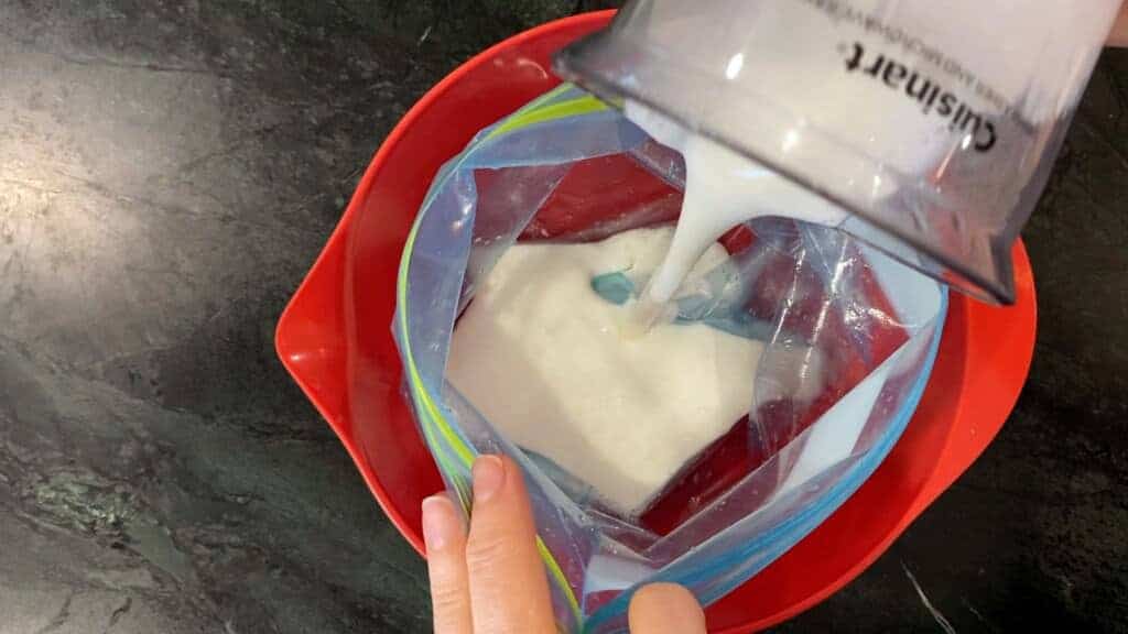 adding 2 cups of buttermilk to a zip top bag to start the chicken curry marinade