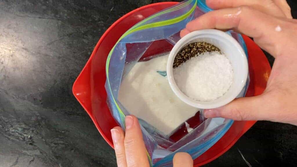 adding salt and pepper to the curry marinade