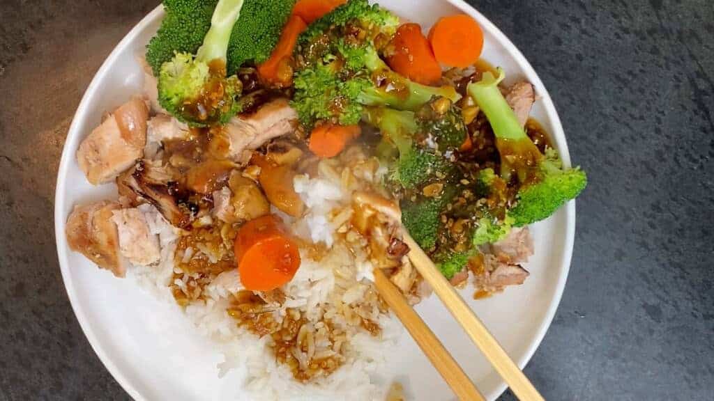 teriyaki chicken bowl being eaten with chopsticks