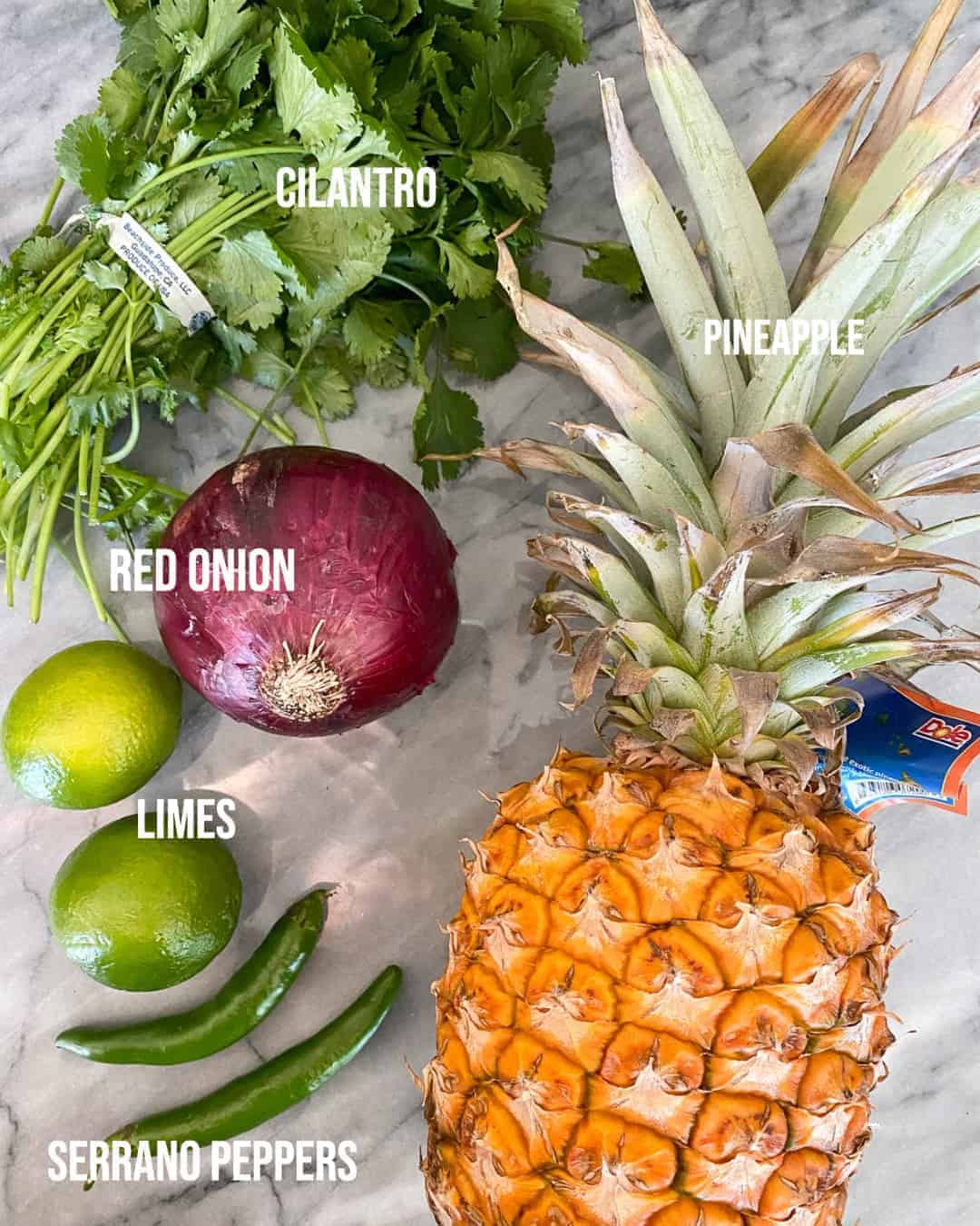 ingredients for pineapple salsa on a marble board