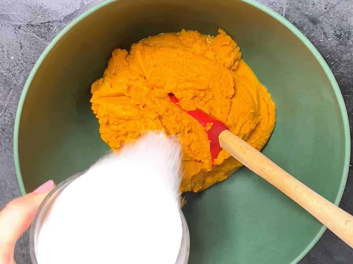 pumpkin puree and sugar, making pumpkin pie filling