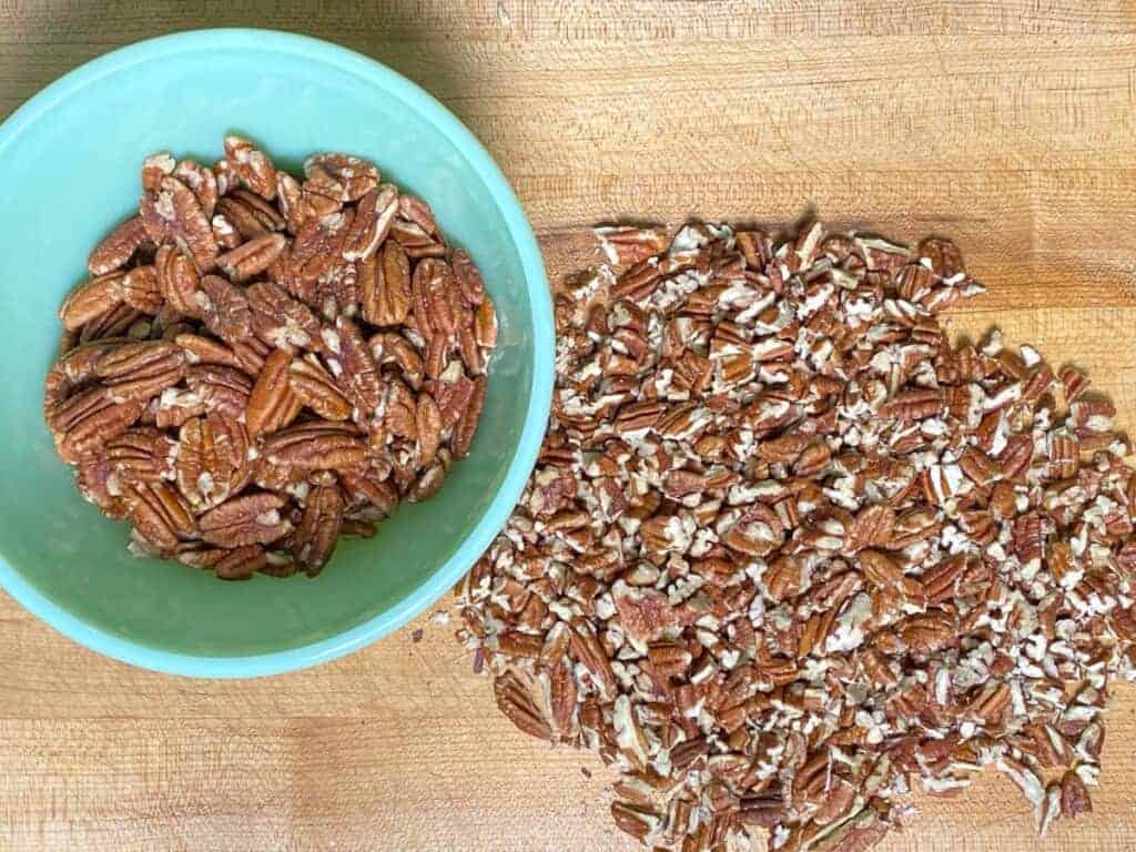 chopped pecan halves on a cutting board