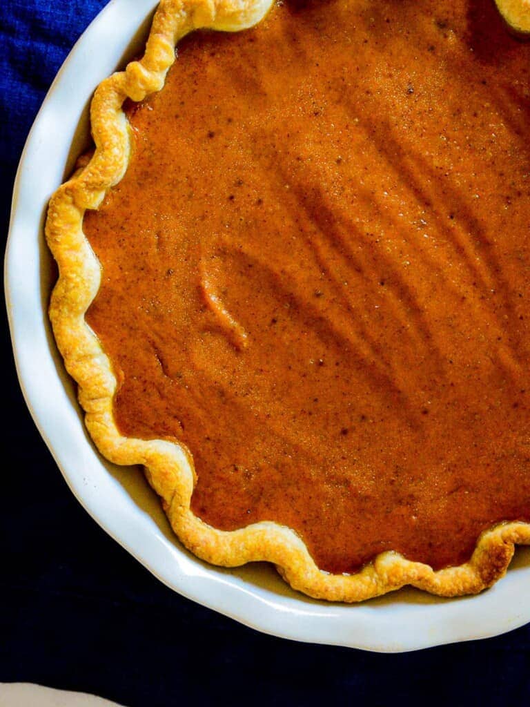 classic pumpkin pie in a white emile henry pie pan