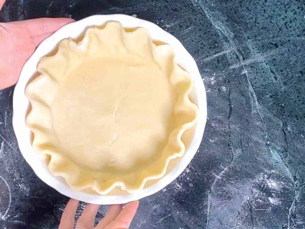 all butter pie dough, unbaked in a white pie dish